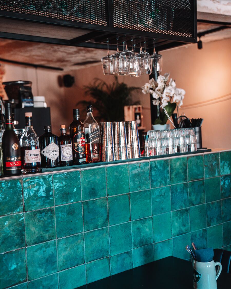 Die Bar mit grünen Kacheln und Gläserregal