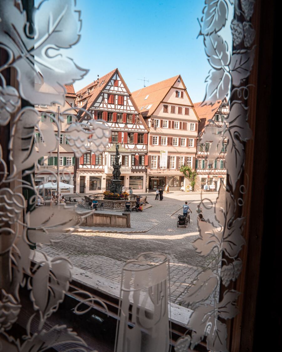 Blick durch ein geätztes Glasfenster auf den Marktplatz